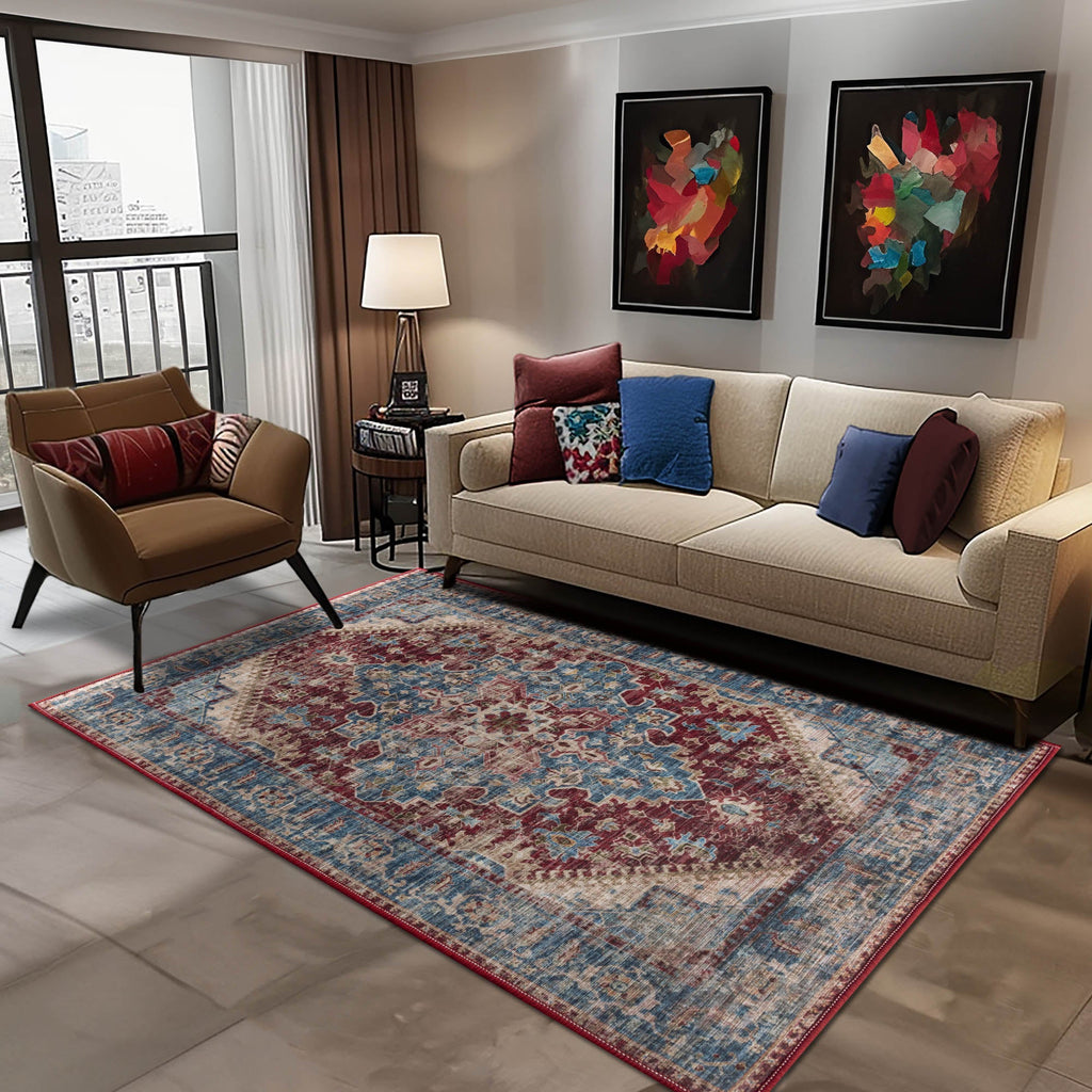 Contemporary living room featuring the Vernal Milagros Ink Blue/Carmine Red/Beige Machine Washable Rug, paired with a cream sofa, modern armchair, and abstract wall art, creating a vibrant and elegant interior setting. 