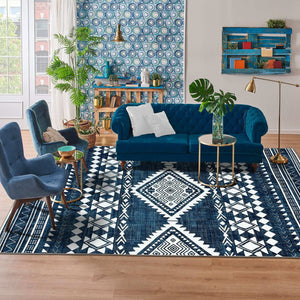 Green Decore Vernal Semey Blue/White Machine Washable Rug styled in a colourful living room with a blue velvet sofa, patterned wallpaper, and indoor plants. This bold tribal rug is anti-slip, stain-resistant, and ideal for vibrant, easy-care home interiors.
