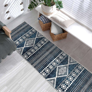 Green Decore Vernal Semey Blue/White Machine Washable Runner placed in a modern entryway with a white bench, storage baskets, and indoor plant. This tribal-style runner is anti-slip, stain-resistant, and perfect for narrow spaces needing stylish, low-maintenance flooring solutions.
