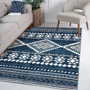 Green Decore Vernal Semey Blue/White Machine Washable Rug styled in a modern living room with neutral furniture and a potted plant. Featuring a bold tribal pattern, this anti-slip, stain-resistant rug adds vibrant character and easy-care convenience to interiors.
