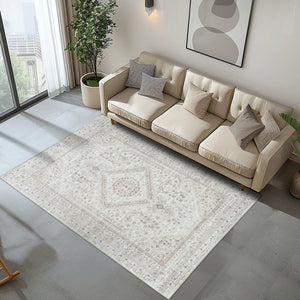 Minimalist living room styled with the Vernal Senglea Beige, Taupe & Cream Machine Washable Rug, placed under a light beige sofa with neutral cushions and a potted plant by the window, offering a calm and elegant aesthetic.
